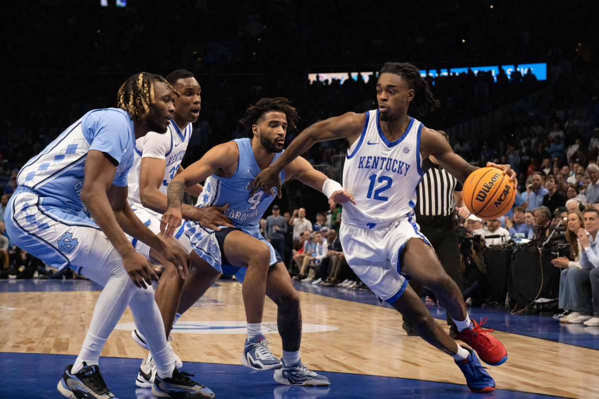 Dec 16, 2023; Atlanta, Georgia, USA; Kentucky Wildcats guard Antonio Reeves (12) dribbles the ball against North Carolina Tar Heels guard RJ Davis (4) and forward Jae'Lyn Withers (24) during the first half at State Farm Arena. Mandatory Credit: Jordan Godfree-USA TODAY Sports